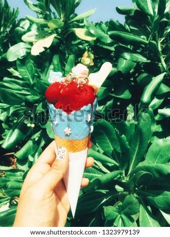 Woman's hand holding melting ice cream waffle cone on a nature background.selective focus.