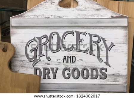Grocery and Dry goods sign made of wood surrounded by wooden cutting boards