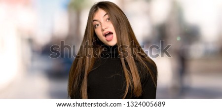 Pretty girl with surprise and shocked facial expression at outdoors