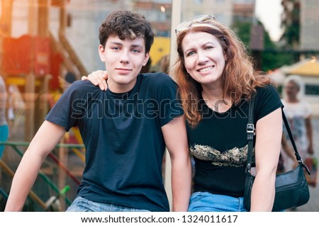 Happy mother hug her teenage son and rejoices because she is reconciled with her son with whom she had a complicated relationship. The son and mother spend their time together Royalty-Free Stock Photo #1324011617