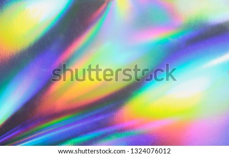Holographic real texture, wrinkled foil in blue pink green colors with scratches and irregularities. Royalty-Free Stock Photo #1324076012