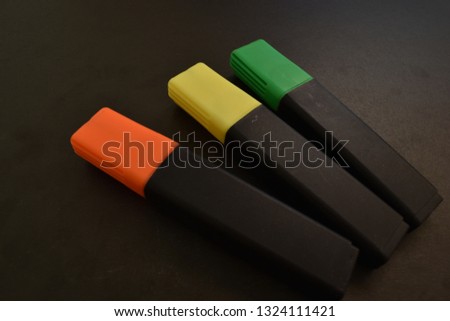 Three markers on a black background.