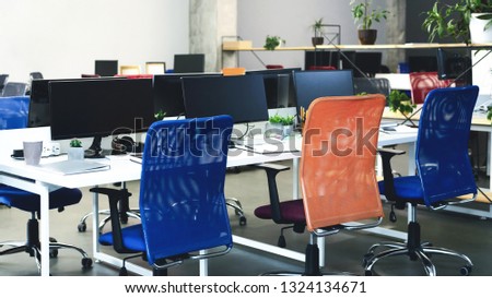 Cozy co-working space for work and education. Office interior with computers and bright colorful chairs, panorama