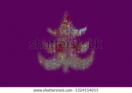 The silhouette of the Christmas tree is out of focus, a blurred image of multi-colored lights. Christmas or New Year. Abstract background, selective focus.