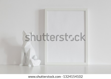 Photo frame mock up and origami fox design home decor on a white table.