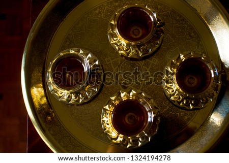 Traditional golden egyptian brass coffee set isolated on the white background. Middle eastern coffee maker with glasses. Golden cups on the white background.