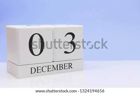 December 03st. Day 3 of month, daily calendar on white table with reflection, with light blue background. Winter time, empty space for text