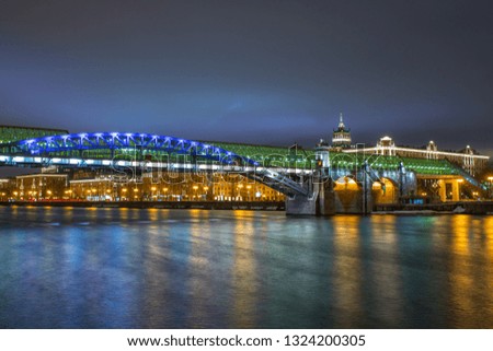 Evening city in the lights, a large bridge over the river.