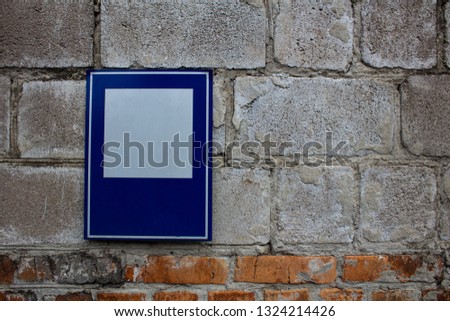 
Blue and white iron plate on a brick wall