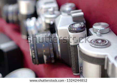 Vintage retro photo equipment at a flea market. Film photo camera on a red background. Stock photography, photo.
