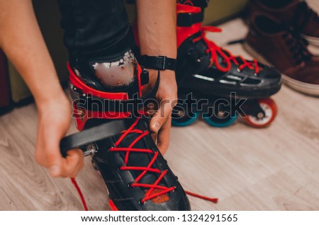 Changing shoes to roller skates on roller rink. A man putting on black skates and setting of laces concept. 