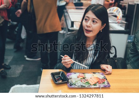 vintage picture of young local woman dining at tradition japanese food restaurant vendor in kuromon ichiba market osaka japan. elegant lady sitting in teeming street enjoy lunch fresh seafood sashimi