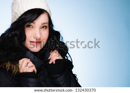 Beautiful girl wearing stocking cap, light blue background, horizon format
