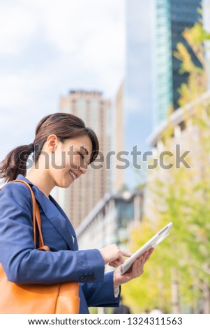Beautiful young asian woman who see a tablet computer