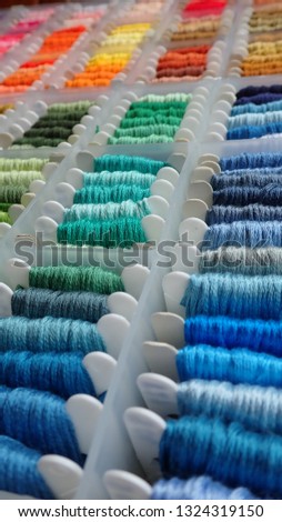 Close up shot of vibrant colorful embroidery floss cross stitch string kit prewound on bobbins for crafts and hobbies