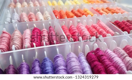 Close up shot of vibrant colorful embroidery floss cross stitch string kit prewound on bobbins for crafts and hobbies Royalty-Free Stock Photo #1324319279