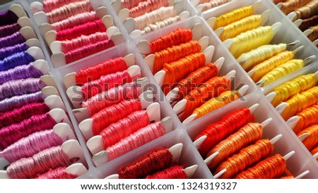 Close up shot of vibrant colorful embroidery floss cross stitch string kit prewound on bobbins for crafts and hobbies