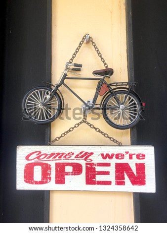 Wooden sign "open" hanging on wall.
