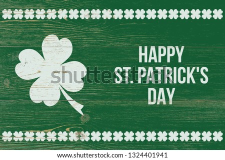 4 leaf clover and white text happy st. patrick's day over green wooden wall