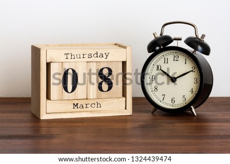 Wood calendar with date and old clock. Thursday 8 March