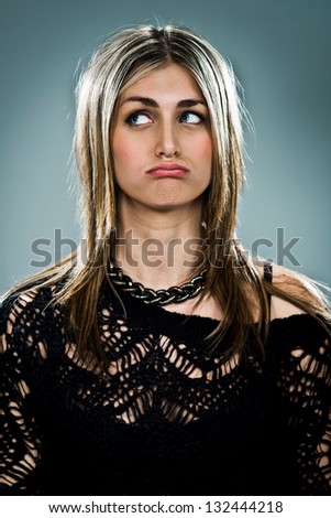 Young Woman with Sad Expression over a Grey Background