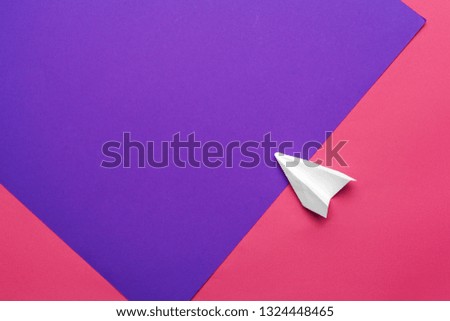 white paper airplane on a color block paper background