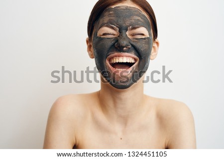 woman in clay mask laughs
