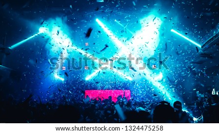 Abstract Background of Party Concert. Cheering happy joyful crowd with raised hands, falling confetti at concert,music festival. Crowd happy and joyful in club.Blur image of concert,Celebration party. Royalty-Free Stock Photo #1324475258