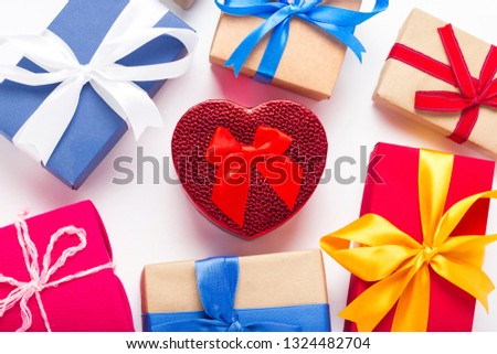 Gift boxes and red gift box in the center of the heart on a white background. Car gift concept, a surprise for a loved one. Flat lay, top view.