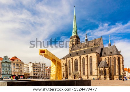 St. Bartholomew's Cathedral in the main square of Plzen with a fountain on the foreground against blue sky and clouds sunny day. Czech Republic, Pilsen. Famous landmark in Czech Republic, Bohemia. Royalty-Free Stock Photo #1324499477