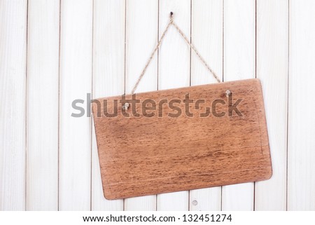 Wooden signboard with rope hanging on white wood planks background