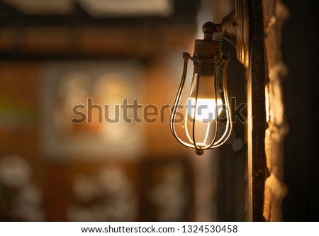 Antique electronic lamp, red wall lamp, high wall lamp, soft light.Red brick wall.Open chain, turn off the lights.hanging at the red brick wall in the building,Wall light brown brick,soft focus. Royalty-Free Stock Photo #1324530458
