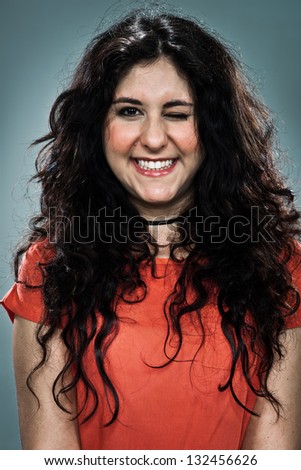 Young Winking Girl Over a Grey Background