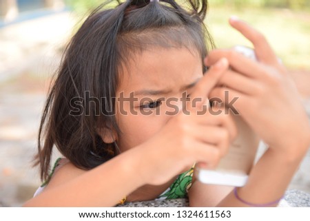 cute kid girl play a smart phone intently