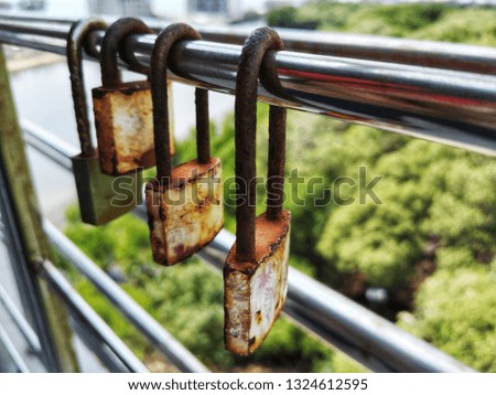 4 old stainless steel locks with a stainless steel fence