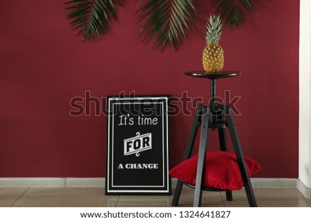 Stool with pineapple and picture near color wall in room