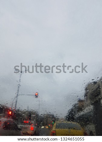 cars stopped at the traffic light in a rainy day