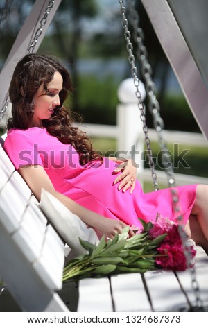 pregnant woman with flowers sitting in the park