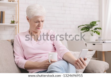 Hyperopia. Woman squinting and holding phone far from eyes, reading smartphone screen Royalty-Free Stock Photo #1324696955