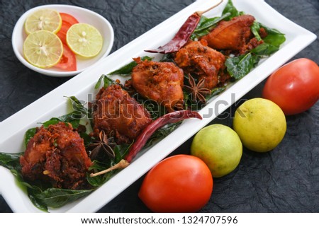 Kerala chicken fry or chicken 65 hot and spicy dish garnished with curry leaves Kerala. a popular authentic roasted dish of South India. fried in a coating of Indian spices.