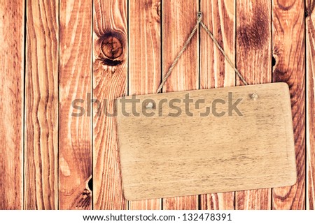 Wooden signboard with rope hanging on wood planks background