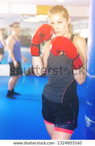 Portrait of young european  woman who is training in box gym.