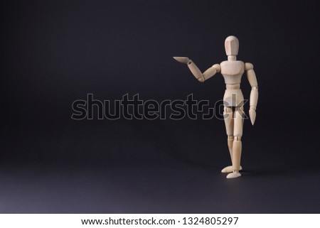 A wooden mannequin shows with his hand. The concept of pointing at someone with your finger. The mannequin will stretch out his hand. Wooden man concept. Wooden mannequin