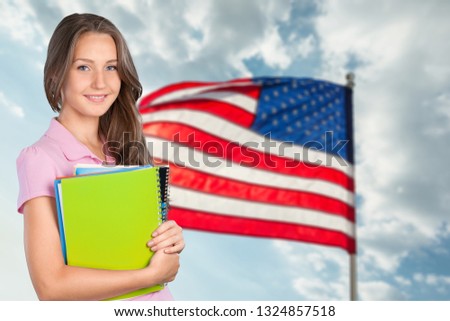 Young female student with books over british flag background