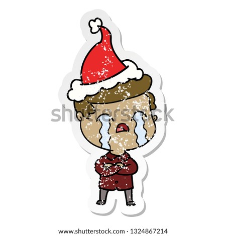 hand drawn distressed sticker cartoon of a man crying wearing santa hat