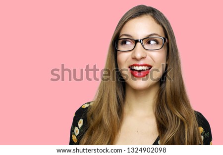 Female eye wear. Attractive brunette girl looking to the side wearing dress retro vintage style over pink background.