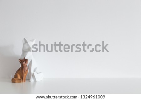 Two origami foxes interior decoration on a desk against white wall mock up.