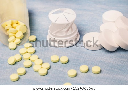 on a blue background are small yellow tablets, and large white ones. there is toning