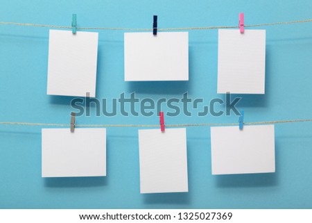 place for photo cards of pleasant and happy moments of life, empty blanks attached to a linen rope with pins on a colored background, template for text, images, idea for home decor