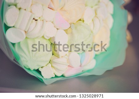 Original delicious edible bouquet consisting of candies, marshmallows and zephyrs on a white background as a gift